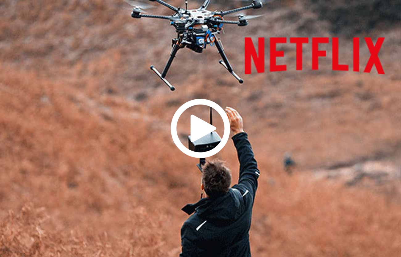 drone pilot stood under flying drone on film set